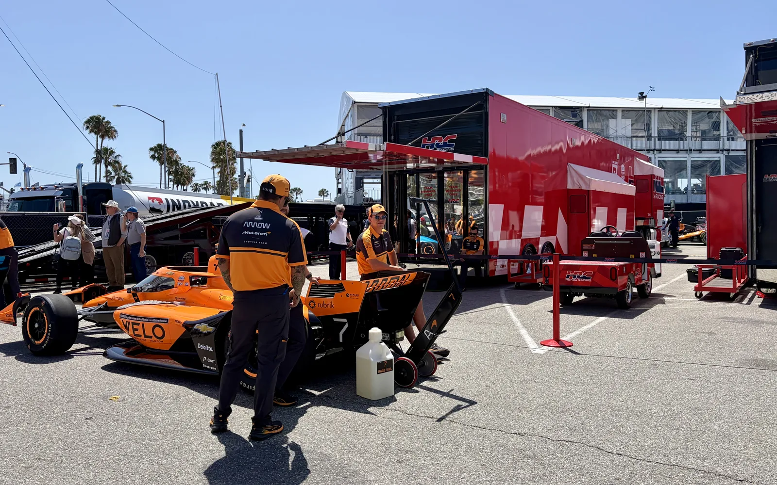An IndyCar racing vehicle competing at the 2026 Acura Grand Prix of Long Beach street race, with the sleek black and orange race car in motion on the downtown circuit.