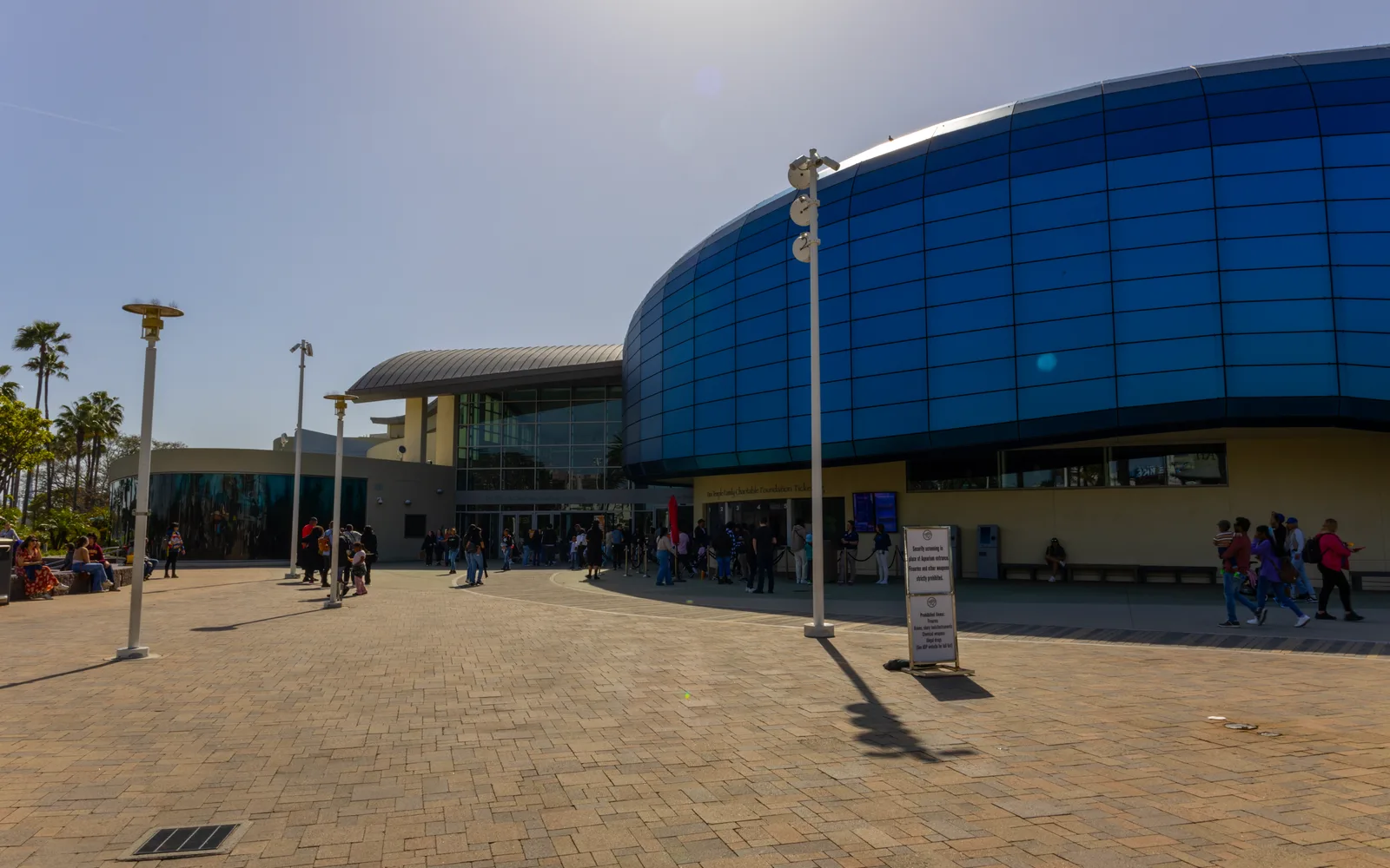 The daytime exterior of the Aquarium of the Pacific, a modern waterfront building in Long Beach with distinctive architecture and landscaping.